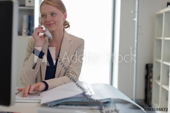 Businesswoman talking on telephone at office desk