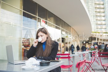 Businesswoman using laptop while having breakfast at pavement cafe