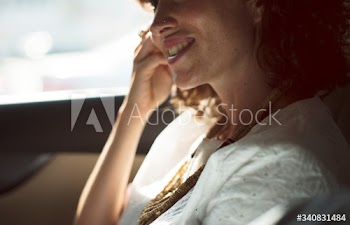 Businesswoman using mobile phone at back seat of the car