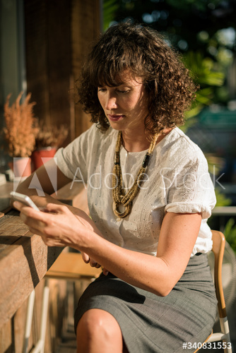 Businesswoman using mobile phone in coffee shop