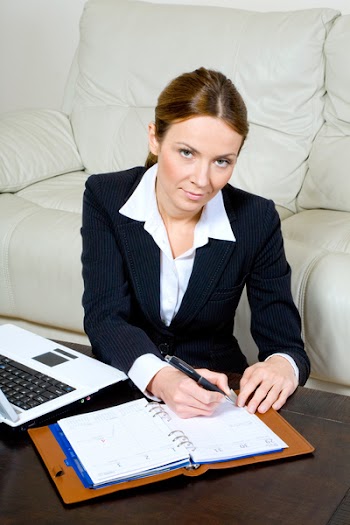 businesswoman with a laptop and diary at her desk