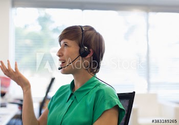 Businesswoman with headset talking on phone in office