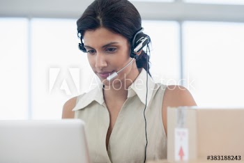 Businesswoman with headset using laptop