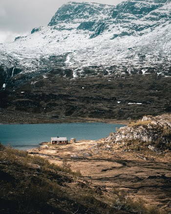 Cabin Beside Body of Water Near Mountain