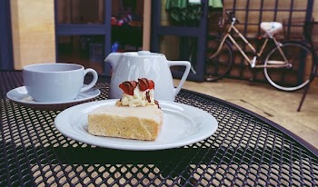Cake on Ceramic Plate Near Teapot and Cups