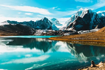 Calm Body of Water and Rocky Mountain