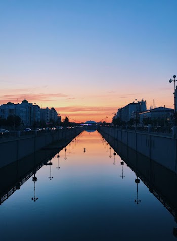 Calm Body of Water in Between Walls and Buildings