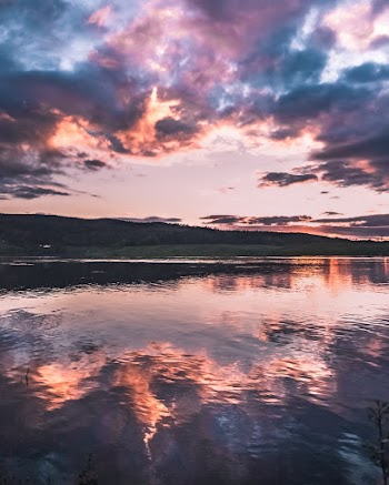 Calm Body of Water Under Dramatic Clouds