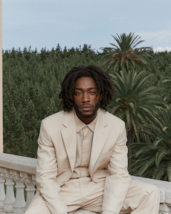Calm Man in Beige Suit Against Lush Greenery