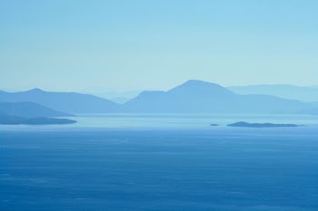 calm water beside mountains at daytime