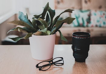 Camera Lens On Brown Wooden Surface