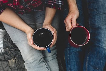 Campers Holding Hot Drinks To Warm Up