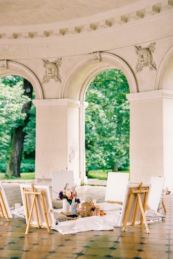 Canvas and Flowers in the Middle of Beautiful Building with Arches  · Free Stock Photo