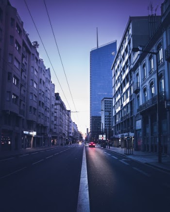 Car on Road Near Concrete Buildings