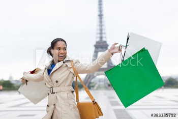 Carefree young woman with shopping bags in front of Eiffel Tower, Paris