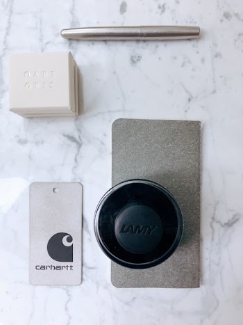 Carhartt Price Tag Beside Lamy Container on Marble Slab