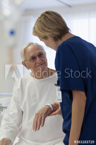 Caring nurse checking on senior patient in hospital room
