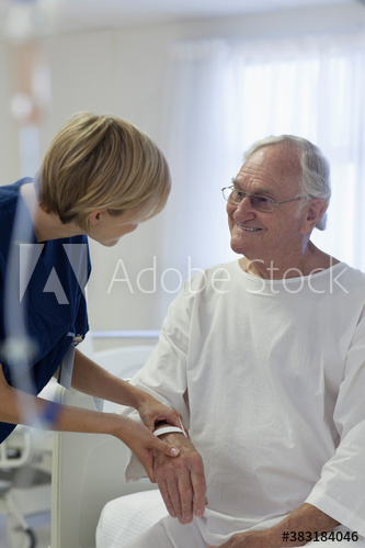 Caring nurse checking on senior patient in hospital room
