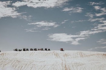 cars on top on white sand hill during daytime