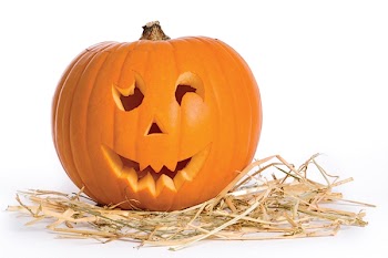 Carved face in pumpkin on a bed of straw
