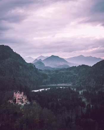 castle on mountain near body of water
