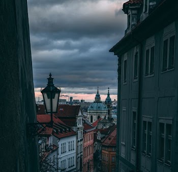 cathedral surrounded by houses under gray clouds during daytime