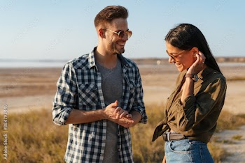 Caucasian happy couple talking and laughing while strolling on nature