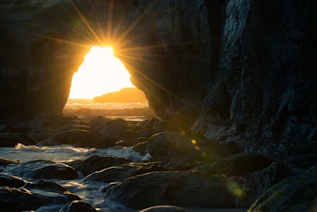 Cave Near Body of Water at Sunset