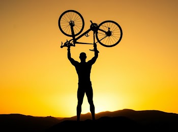 Celebrating Victory: Silhouette of a Cyclist at Sunset