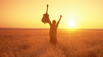 Celebratory Guitarist in Wheat Field at Sunset