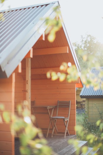 Chair Beside Table  In Front Of An Orange Wooden Shed 