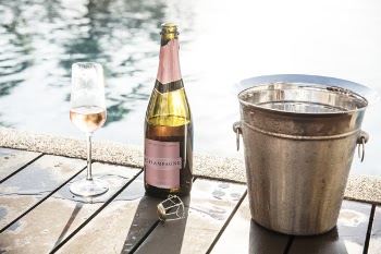 Champagne Bottle Near Champagne Glass and Gray Bucket