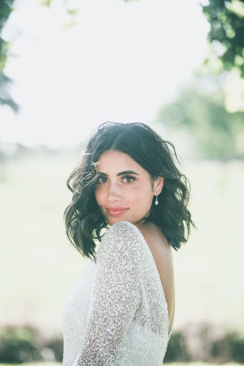 Charming female in elegant dress standing in park and looking at camera · Free Stock Photo
