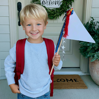 Cheerful Boy with Backpack and Triangular Flag on Porch