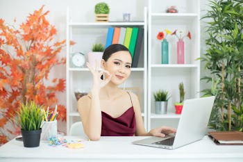 Cheerful business lady working on laptop in office Free Photo