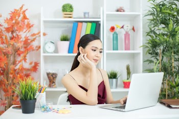 Cheerful business lady working on laptop in office Free Photo