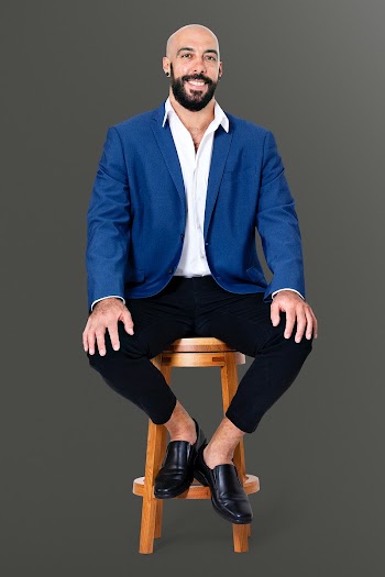 Cheerful businessman sitting on a wooden… | Free stock photo | High Resolution image