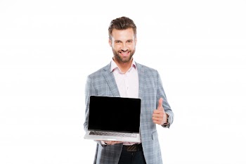 Cheerful young man holding laptop showing thumbs up. Free Photo