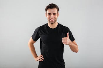 Cheerful young sports man posing showing thumbs up gesture. Free Photo
