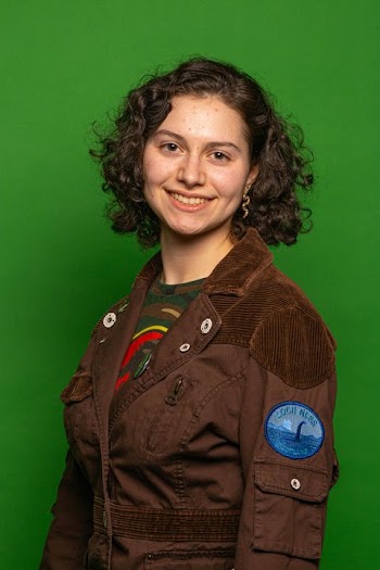 Cheerful Young Woman in Casual Brown Jacket with Green Background