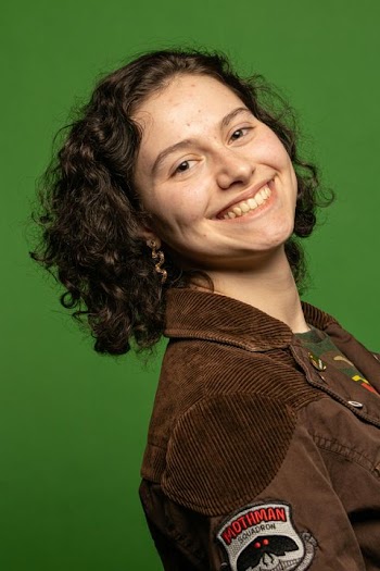Cheerful Young Woman with Curly Hair on Green Background