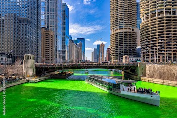 Chicago building and cityscape on Saint Patrick's day around Chicago river walk with green color dyeing river in Chicago Downtown, illinois, USA, crowned irish and american people are celebrating.