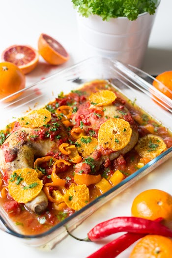 Chicken legs with tomatoes, peppers and oranges 
