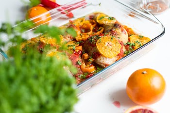 Chicken legs with tomatoes, peppers and oranges 