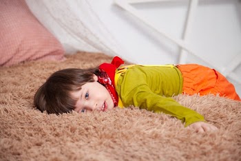 Child Lying On Brown Fur Textile