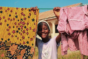 Child Smiling Holding Hanging Line with Clothes