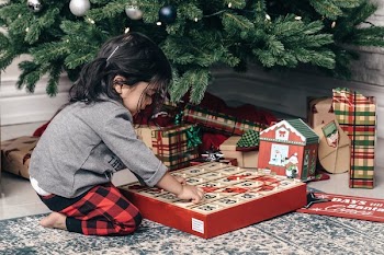 Child With Advent Calendar Under Christmas Tree