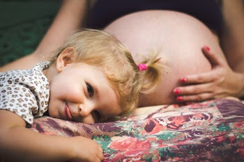 Children Lying in Front of the Pregnant Woman