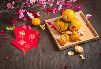 Chinese new year wooden table top shot with red packet printed with word "Blessing" and tangerine oranges. 