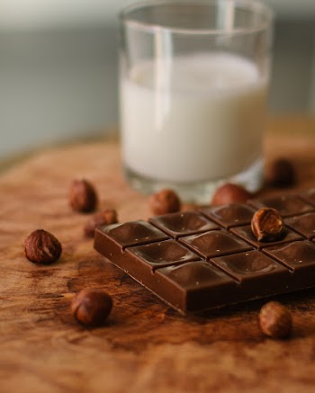 Chocolate Beside Clear Drinking Glass With Milk